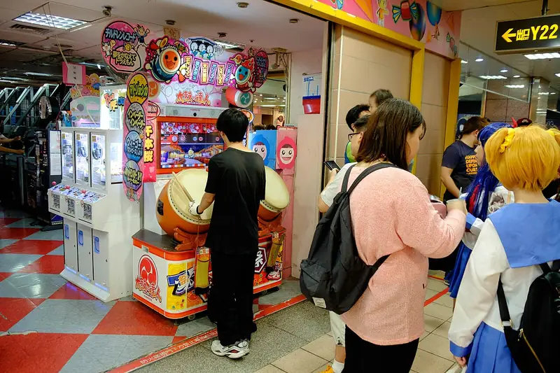 People playing arcade machines at a busy game centre