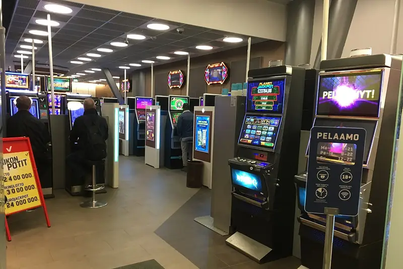 Rows of video slot machines with players on a casino floor